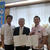 満タン運動のノボリを背に浦添市との災害時協定に調印した沖縄石商の濱元理事長（右から２人目）