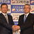 社長交代の記者会見で握手する森川社長（右）と桐山副社長